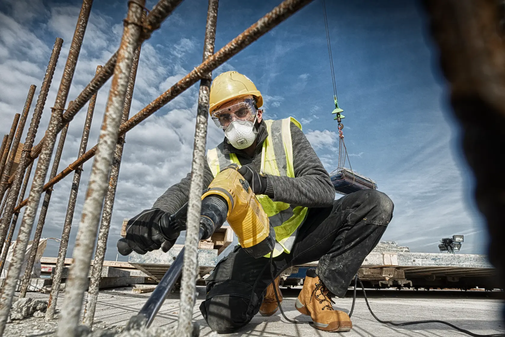 DEWALT D25481K, D25481 Bohrhammer im Einsatz auf Baustelle; Arbeiter bohrt Beton bei Bewehrung.