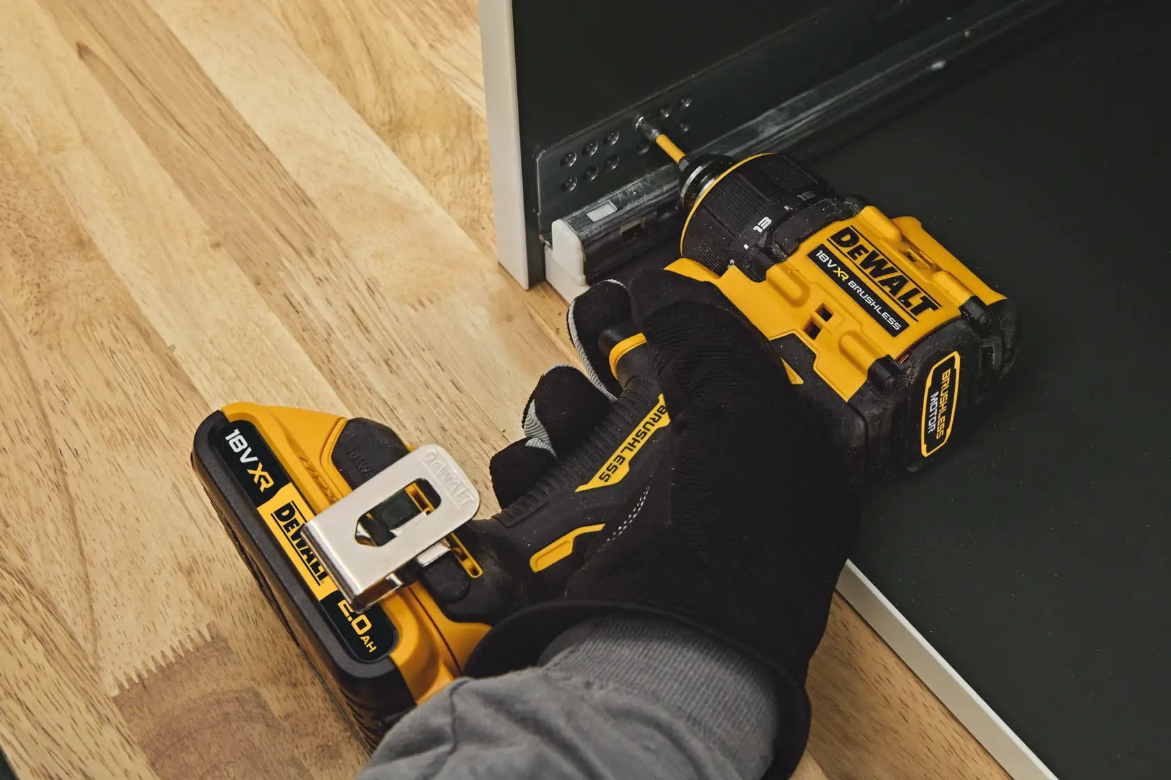 DEWALT drill DCD803D2T-QW, DCD803D2T in use assembling furniture, close-up on tool and worker's hand.