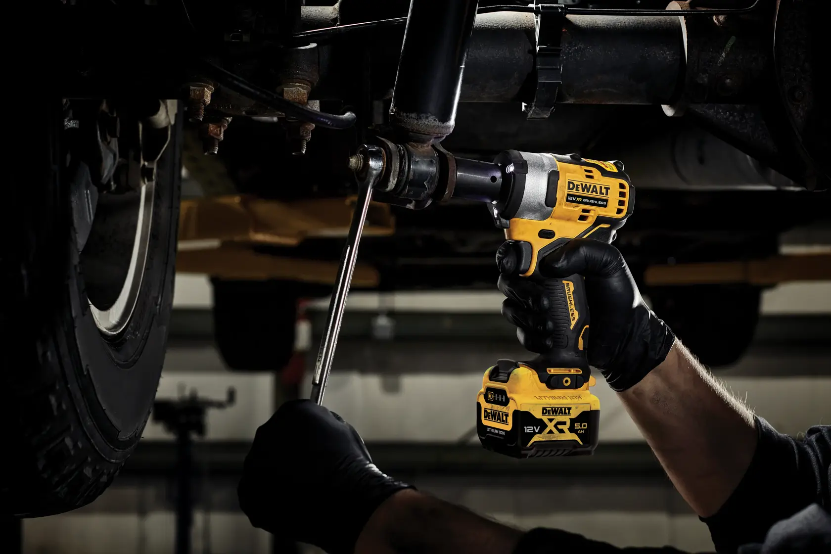 DEWALT DCF903P1 cordless impact wrench being used under a vehicle for mechanical work.