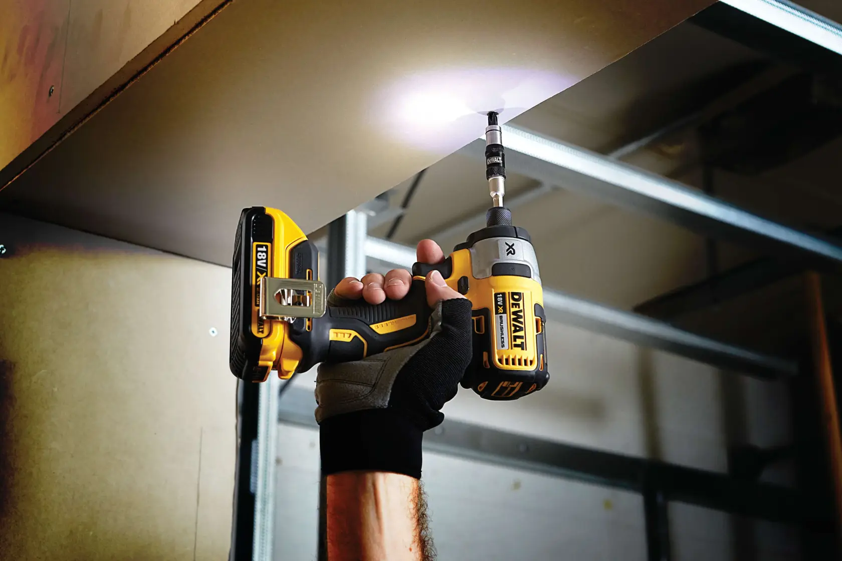 Persona usando un taladro inalámbrico DEWALT para atornillar en un panel de techo.