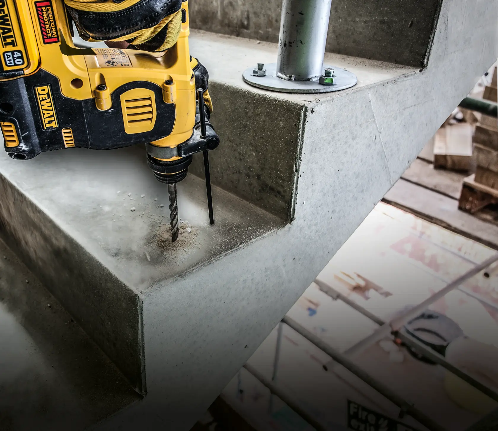 Taladro DEWALT perforando un agujero en una escalera de cemento en construcción.