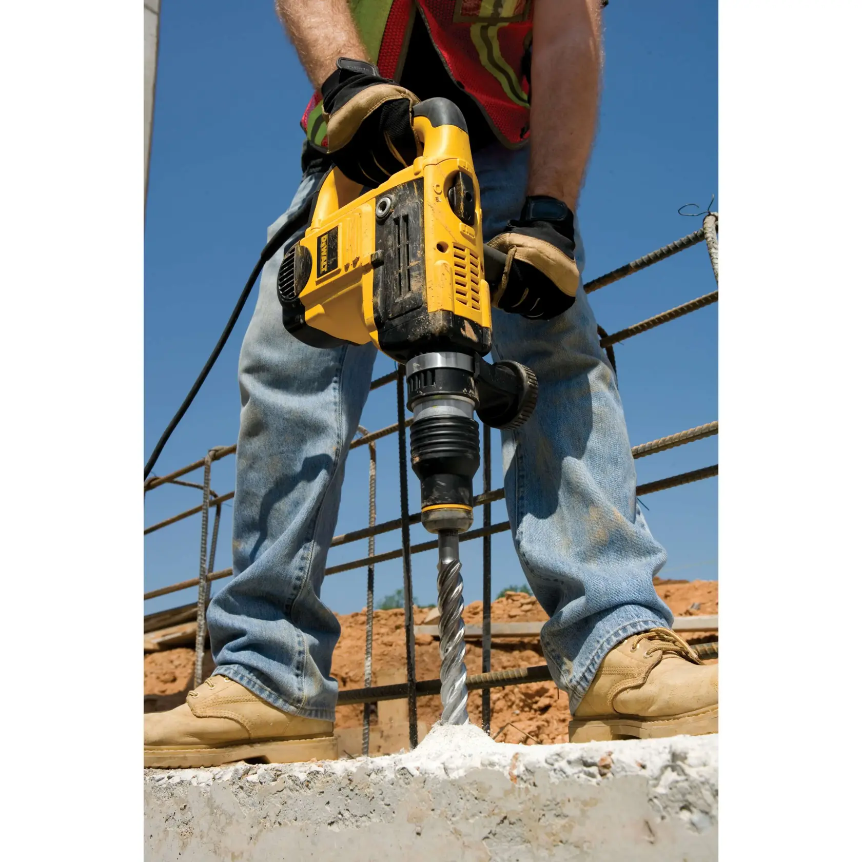 Arbeiter bohrt mit gelbem DEWALT-Hammer und DT9433-Bit in Beton auf einer Baustelle.