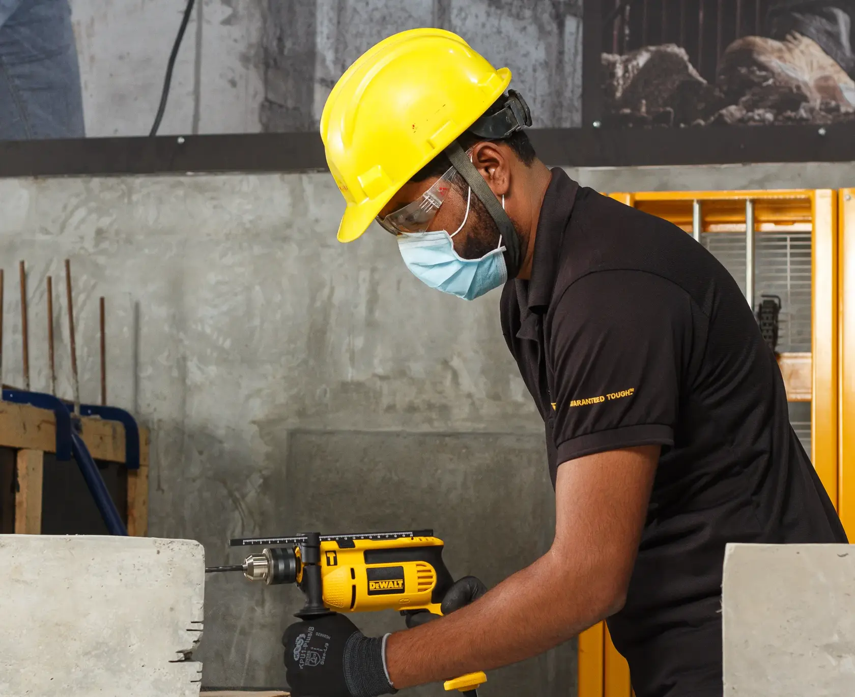 Worker uses DEWALT drill, models DWD024-QS and DWD024, for concrete drilling in construction setting.