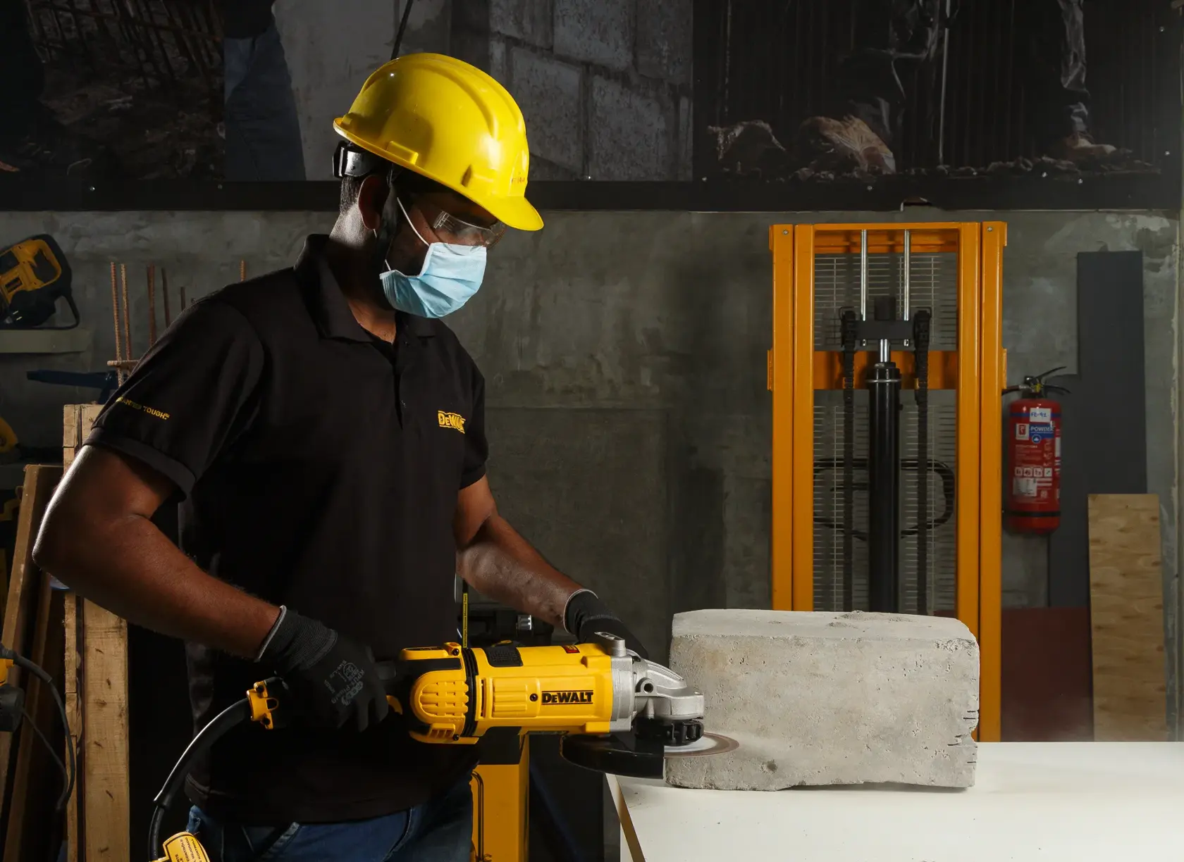 Persona cortando bloque de concreto con amoladora DEWALT, usando equipo de seguridad y guantes.
