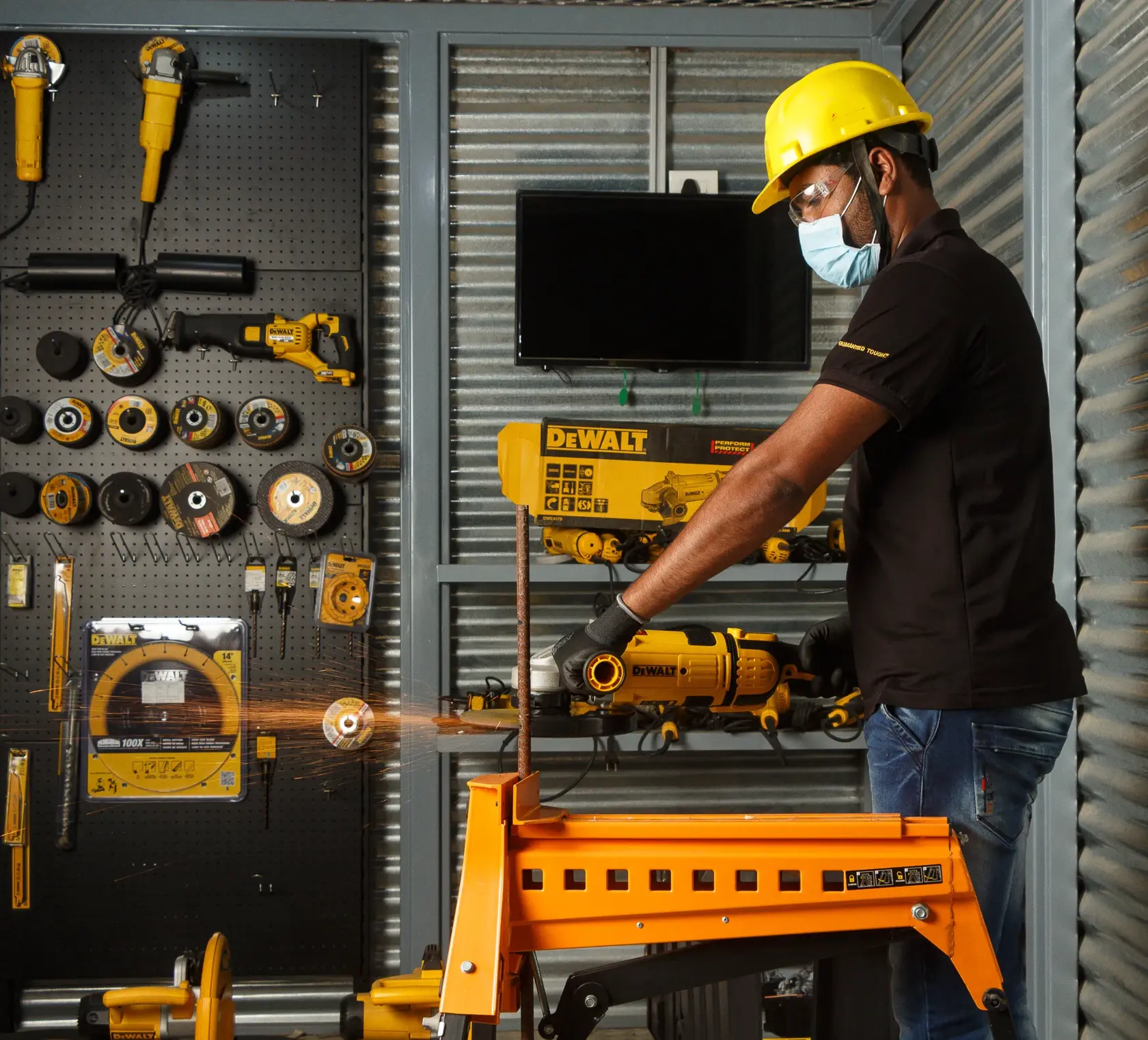 Trabajador corta metal con herramienta DEWALT, usa protección. Se ven herramientas en el fondo.